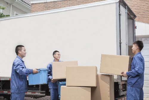 Packed moving boxes and furniture being loaded into a van
